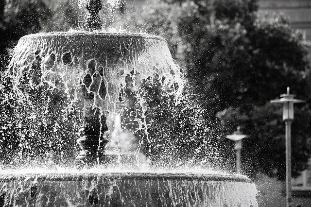 black and white photo of a water fountain spraying water to and fro
