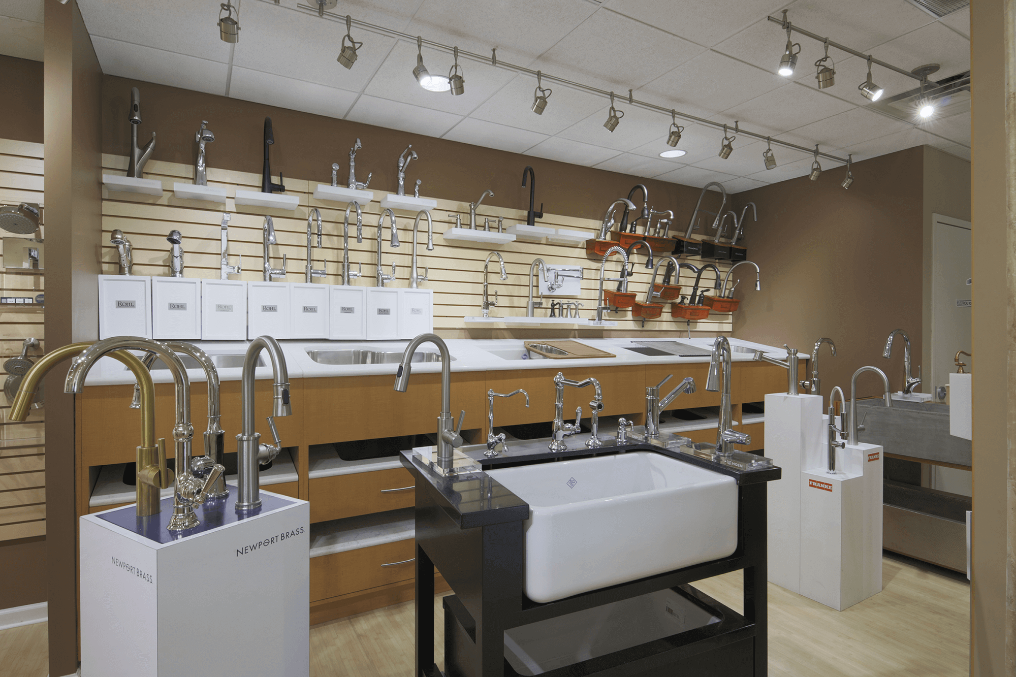 kitchen showroom featuring several silver-colored metal faucets on standalone sinks