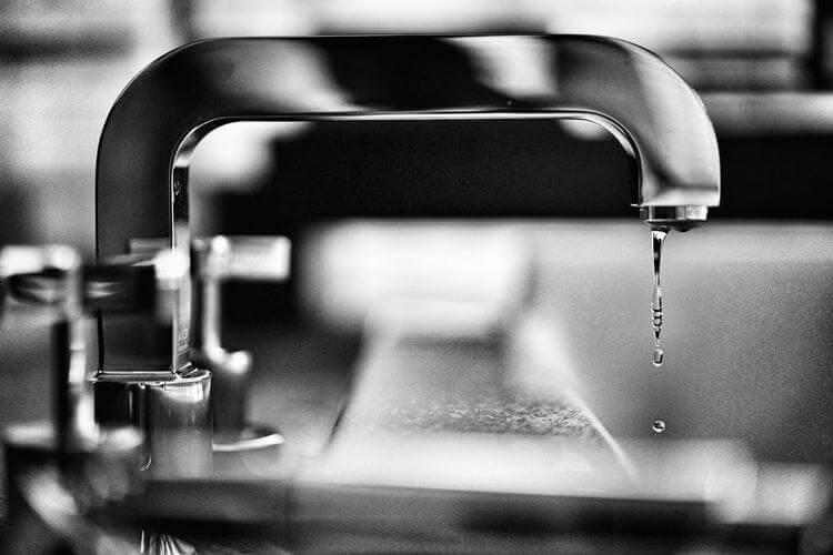 Black and white image of a sink and dripping water